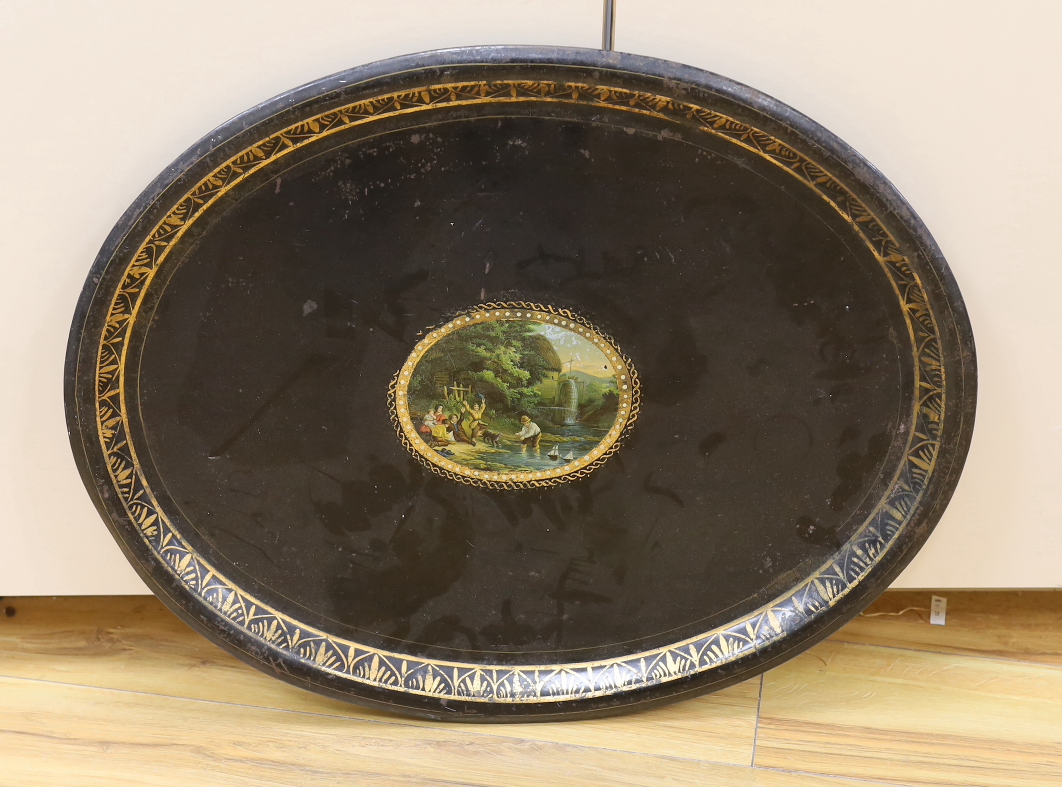A Victorian toleware tray with transfer cartouche of children playing with model boats, width 60cm
